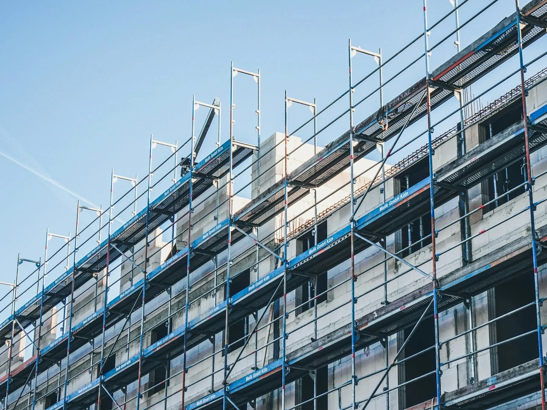 Steel scaffolding extending along a light building facade