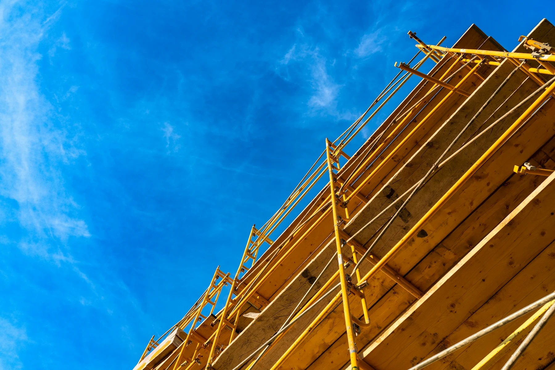 Yellow scaffold platforms seen against a clear blue sky
